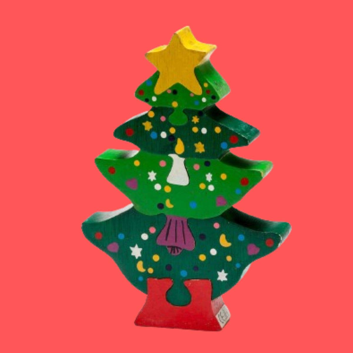 Colorful wooden Christmas tree ornament on a red background