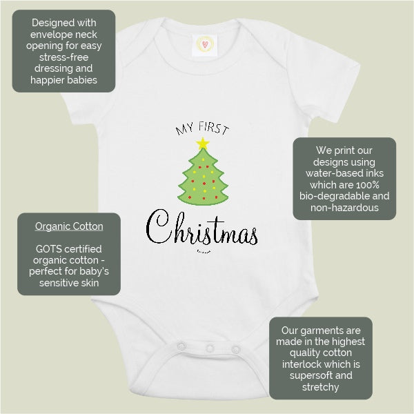 White baby bodysuit with a green Christmas tree graphic and the text 'MY FIRST Christmas' on the front, shown on a light beige background with five dark gray text callout boxes describing product features and materials.