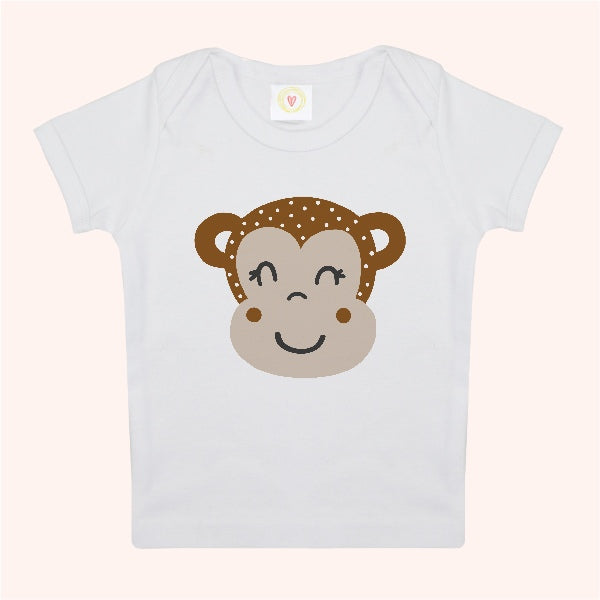 White t-shirt with a monkey face design on a light pink background