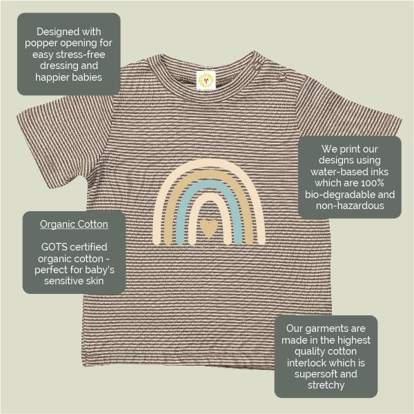 Baby shirt with rainbow design and text about organic cotton and printing methods on a beige background