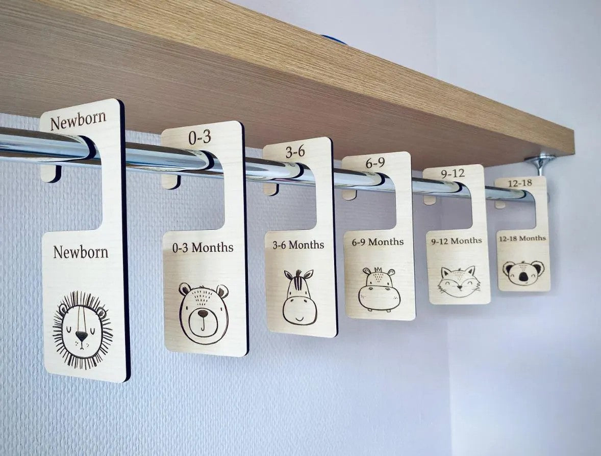 Clothing size labels with animal illustrations on a wooden shelf.