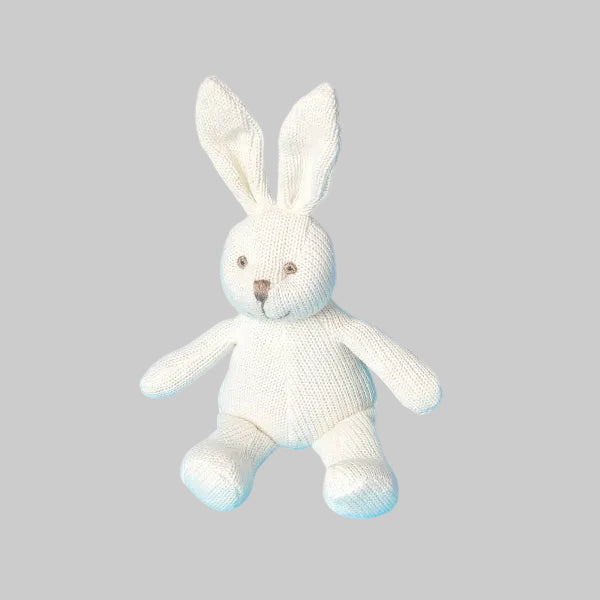 White knitted bunny toy on a grey background