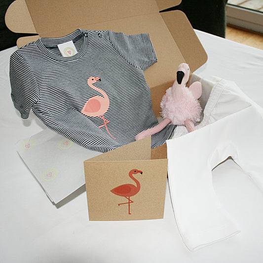 “Flamingo-themed organic cotton baby gift box with striped top, white leggings, and plush rattle”