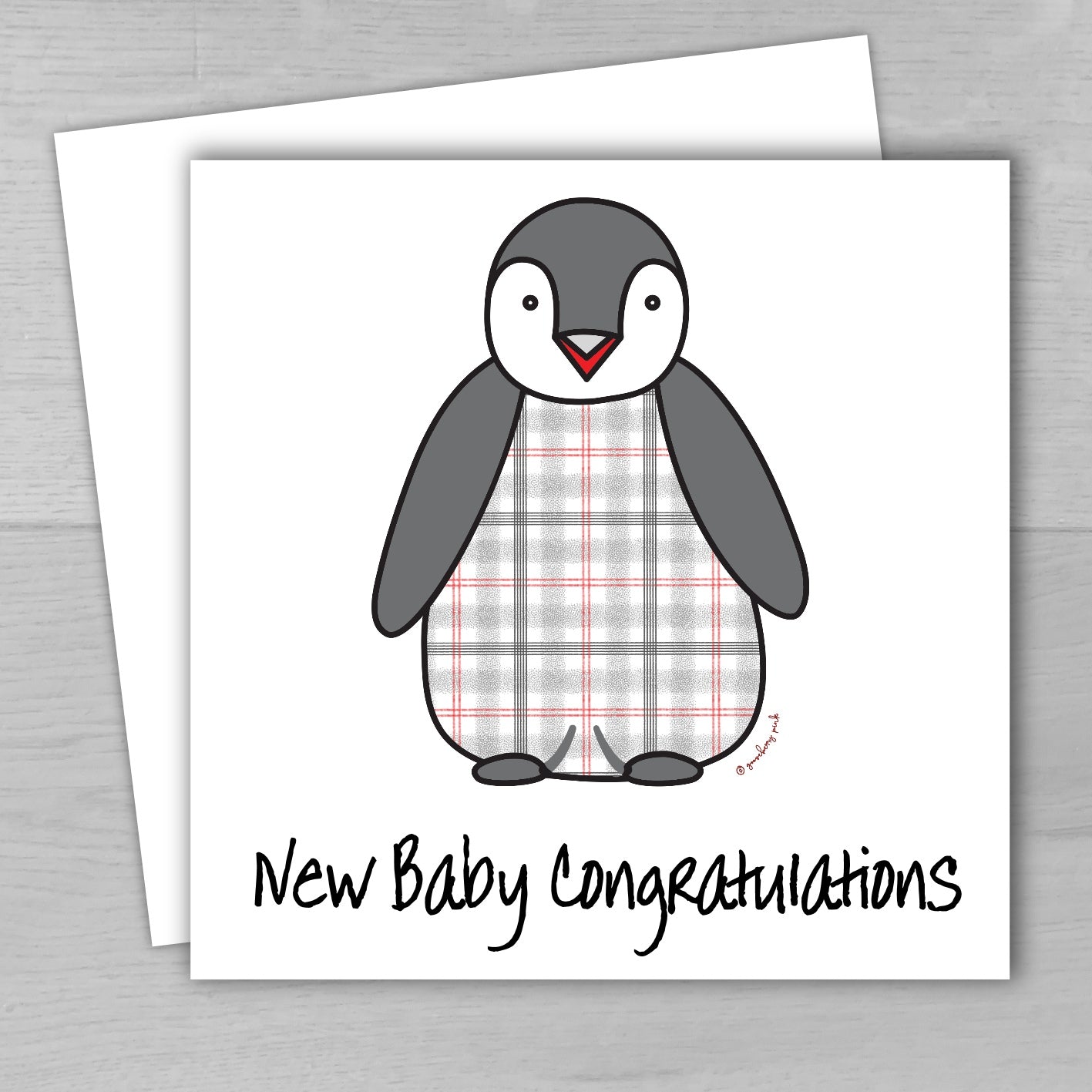 A new baby greeting card with a cute tartan penguin design, accompanied by a matching recycled envelope. The card is displayed with a 'New Baby Congratulations' message.