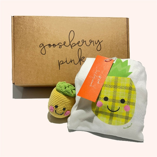 Pineapple-themed New Baby Gift Box with organic cotton bodysuit and soft toy rattle