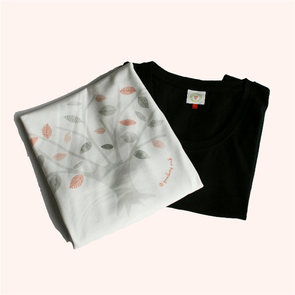Black t-shirt and white fabric with leaf pattern on a white background