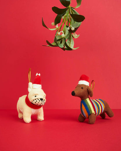 Two knitted dog toys on a red background with mistletoe.