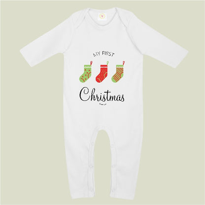 A white long-sleeve baby bodysuit with a festive graphic on the chest reading 'MY FIRST Christmas' and three Christmas stockings, shown against a solid light sage green background.