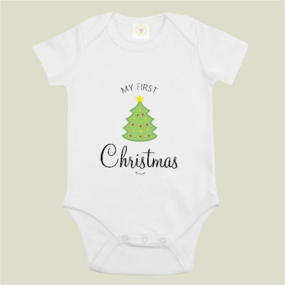 A white short-sleeve baby bodysuit with a graphic print of a green Christmas tree and the text 'MY FIRST Christmas' on a light beige background.