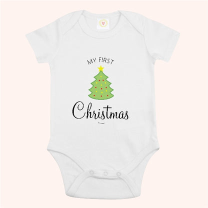 A white short-sleeve baby bodysuit with a graphic print of a green Christmas tree and the text 'MY FIRST Christmas' on a pale pink background.