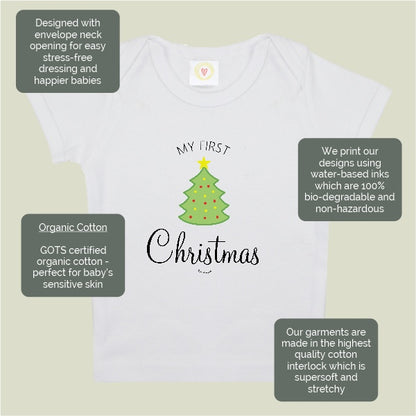 White long-sleeve baby t-shirt with a green Christmas tree graphic and the words 'MY FIRST Christmas' on the front, shown on a light beige background with four dark gray feature callout boxes.