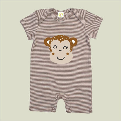Striped baby romper with monkey face design on a beige background
