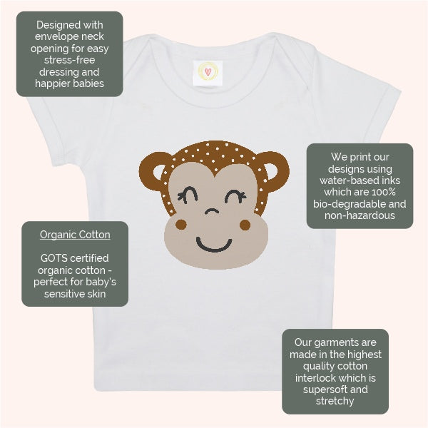 Baby t-shirt with monkey design and certification labels on a white background