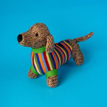 Knitted dog toy with a colorful striped sweater on a blue background