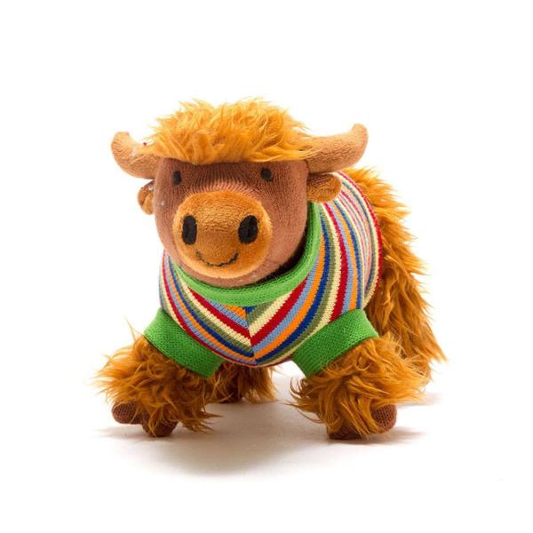 Stuffed animal toy cow wearing a colorful sweater on a white background