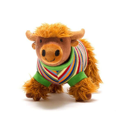 Stuffed animal toy cow wearing a colorful sweater on a white background