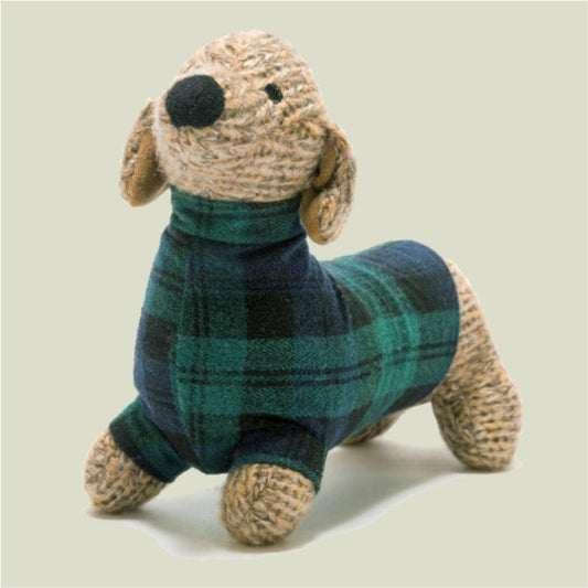 Stuffed dog toy wearing a green and blue plaid sweater on a beige background