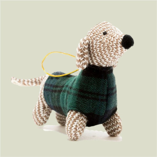 Knitted dog toy with a green sweater on a light gray background