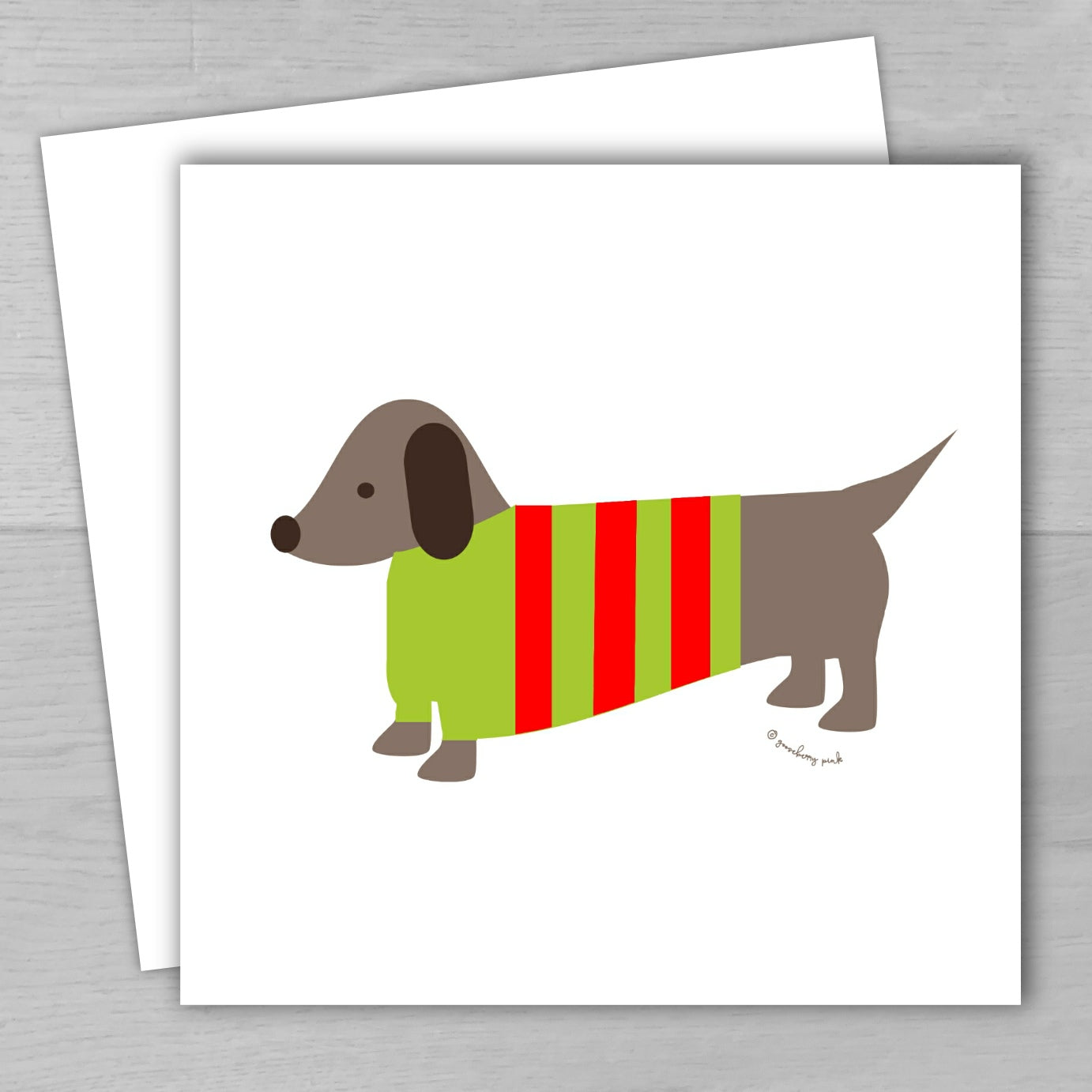 Illustration of a dachshund wearing a green and red striped sweater on a white card.