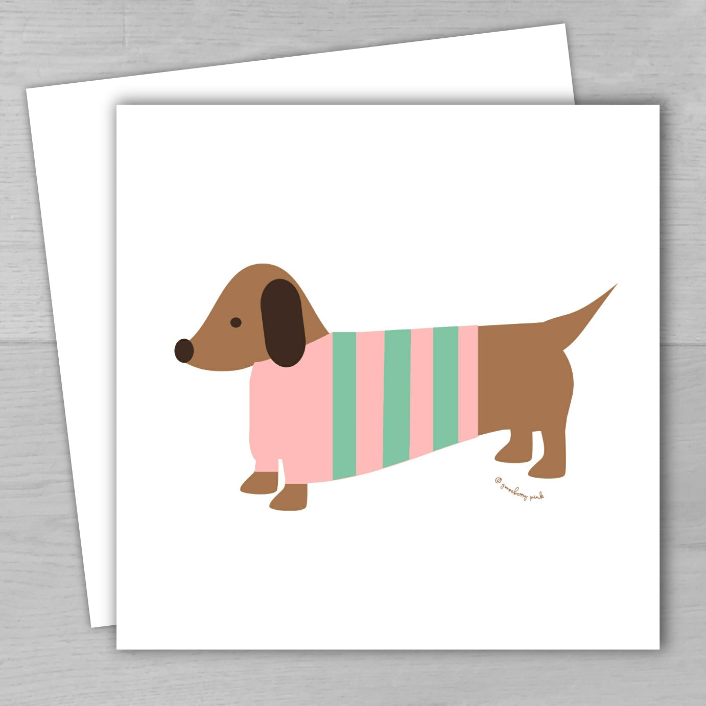 Illustration of a dachshund wearing a striped sweater on a white card with a gray background.
