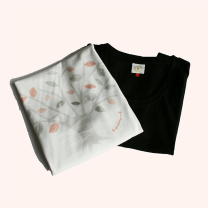 Black t-shirt and white fabric with leaf pattern on a white background
